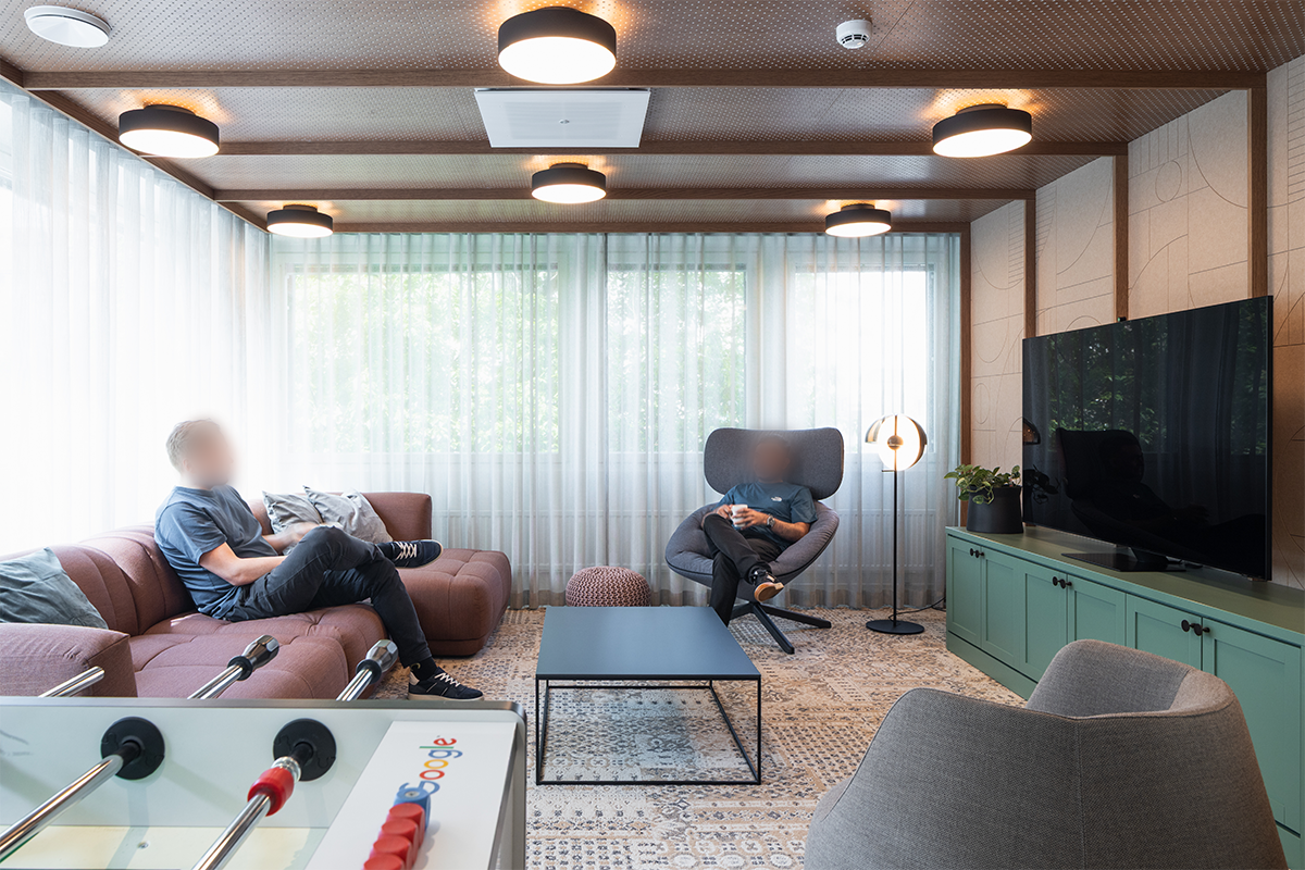 Googlen uuden Suomen pääkonttorin tila, jossa henkilöstöä istuu rennosti istuskeluryhmän lounge kalusteilla.